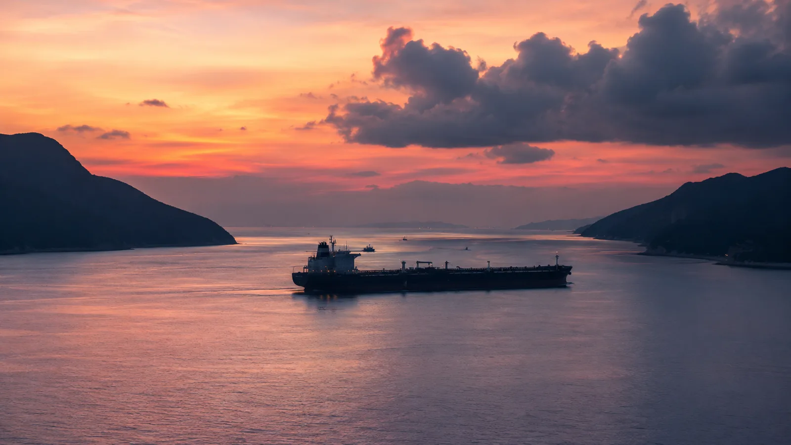 A maritime corridor at dawn - calm water reflecting an unresolved horizon, representing the May 2026 Hormuz pause